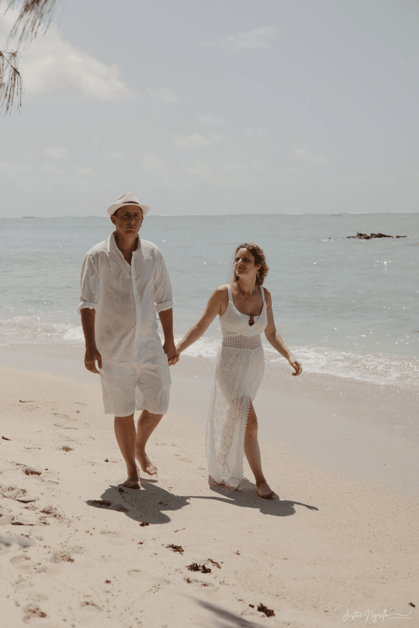 Mélanie et Loïc marchant sur une plage de l’Île Maurice pendant leur voyage de noces