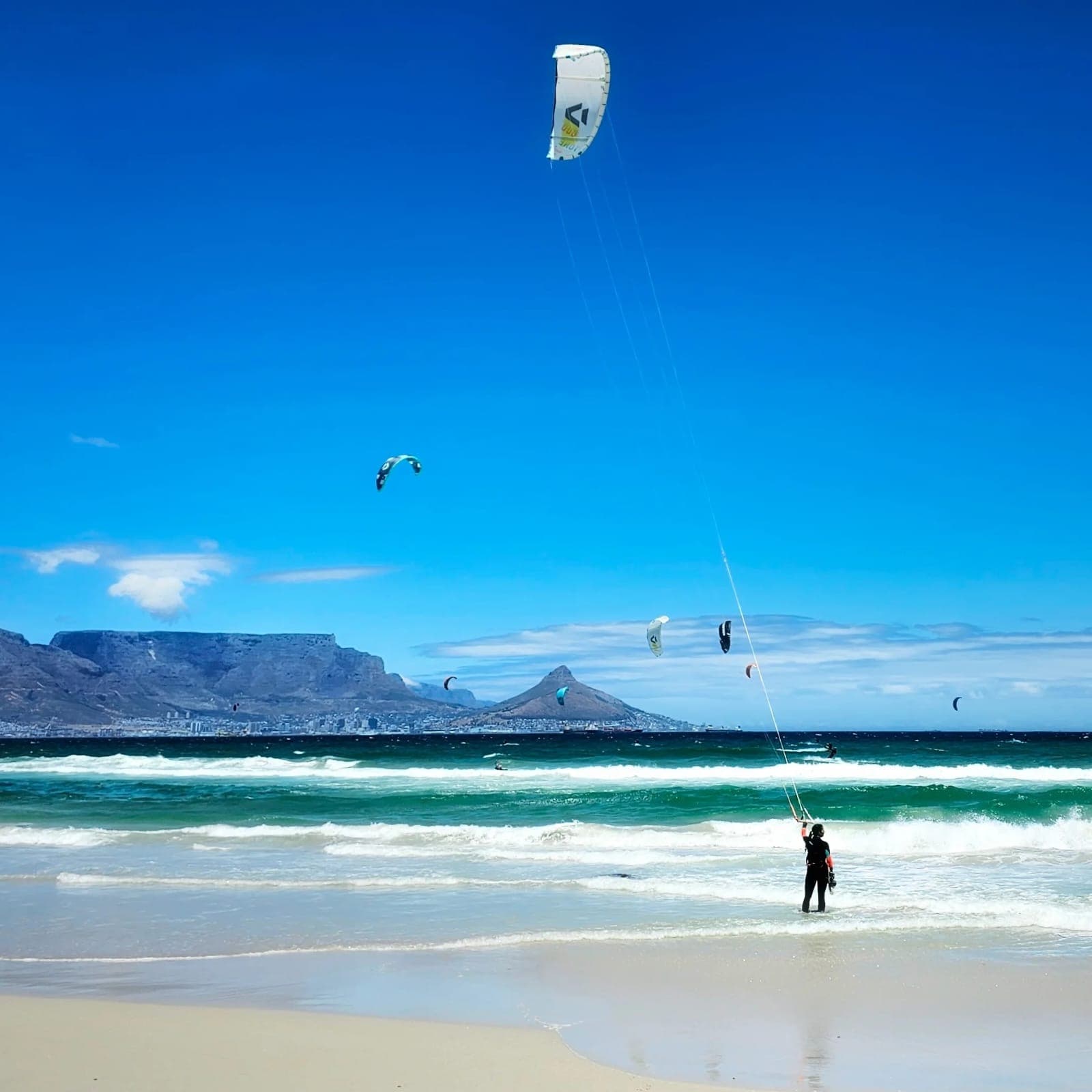 Kitesurf sur une plage du Cap avec Table Mountain en arrière-plan