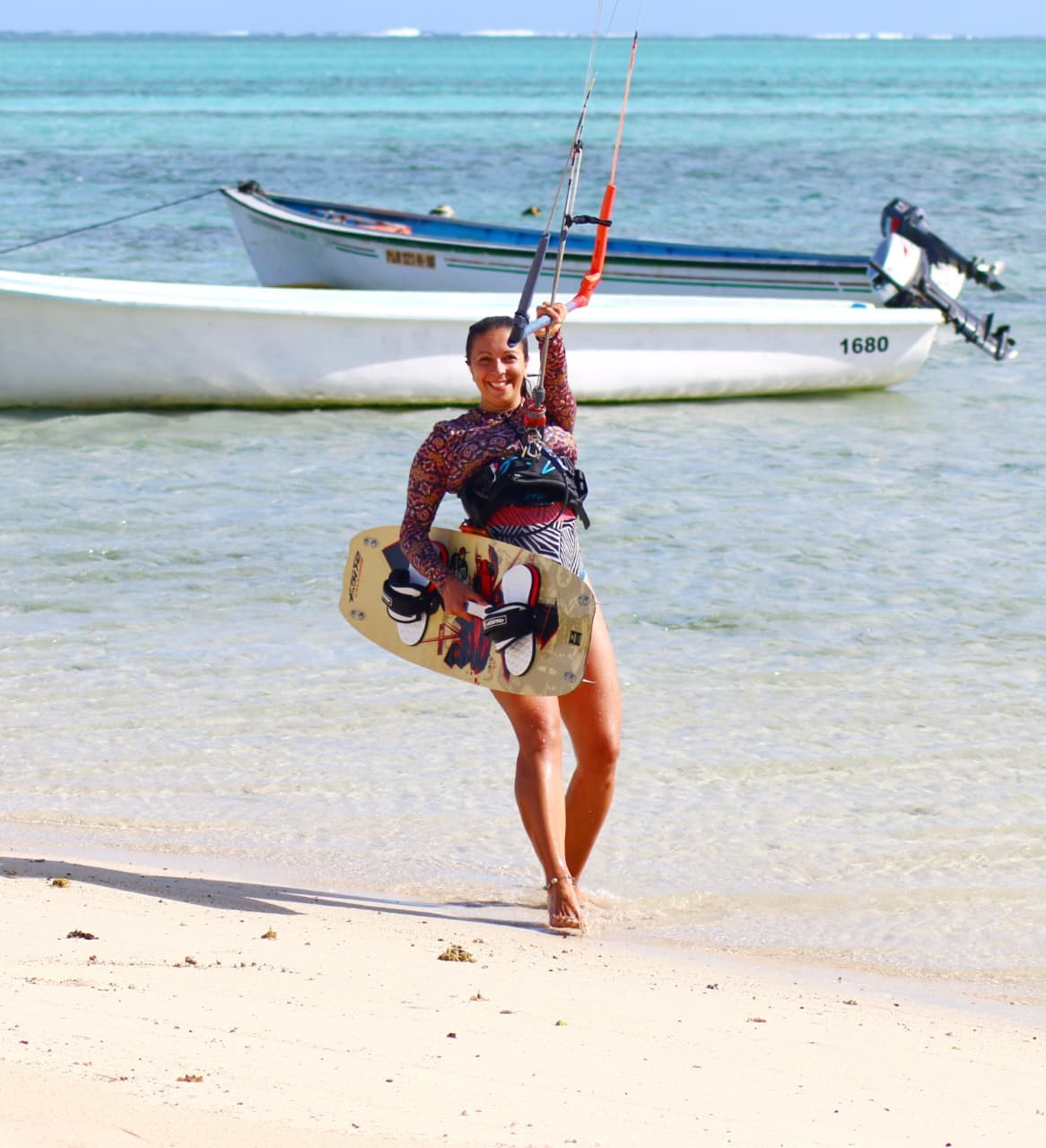 Anaïs souriante avec son kitesurf sur une plage mauricienne