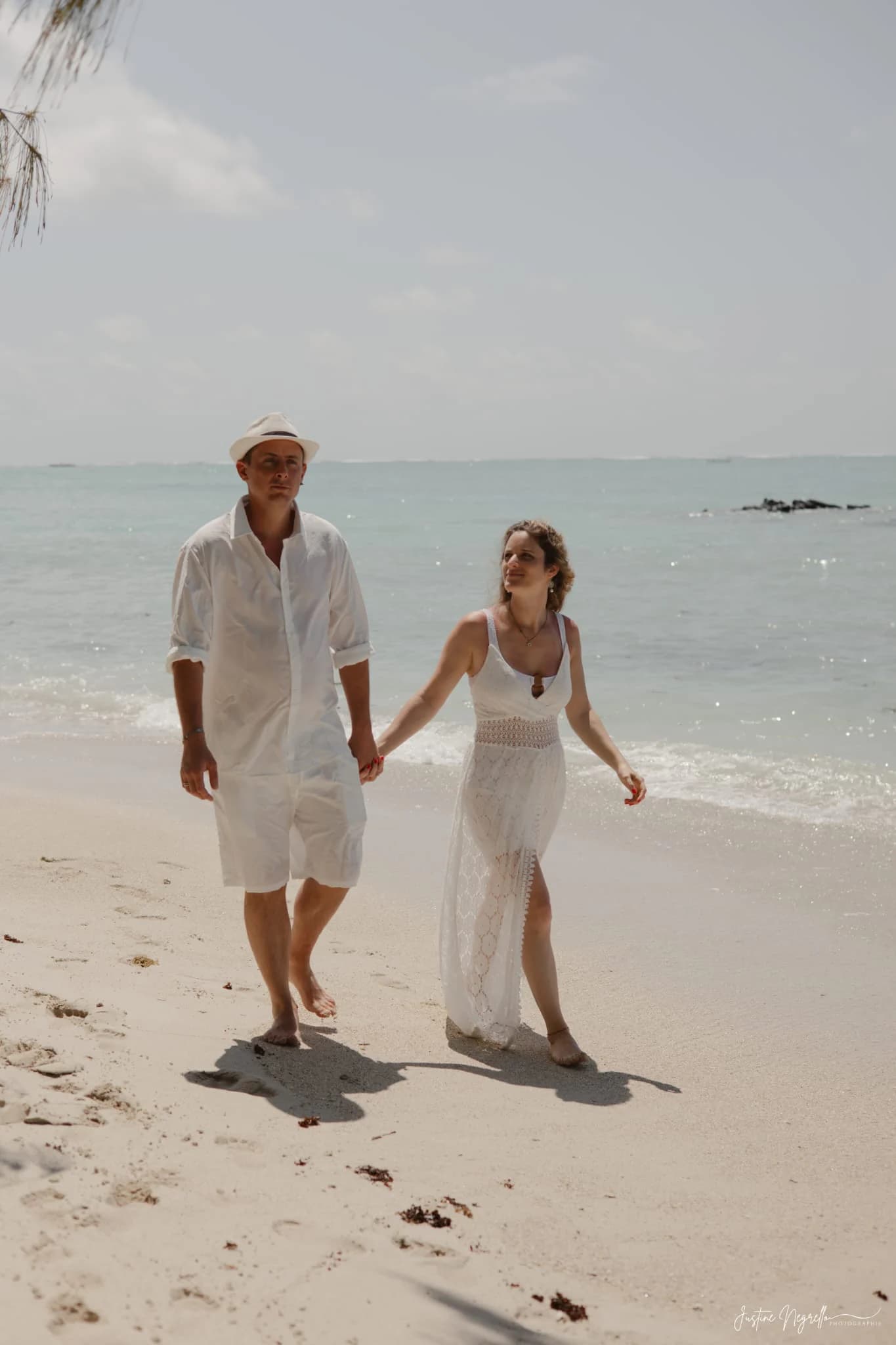 Mélanie et Loïc marchant sur une plage de l’Île Maurice pendant leur voyage de noces
